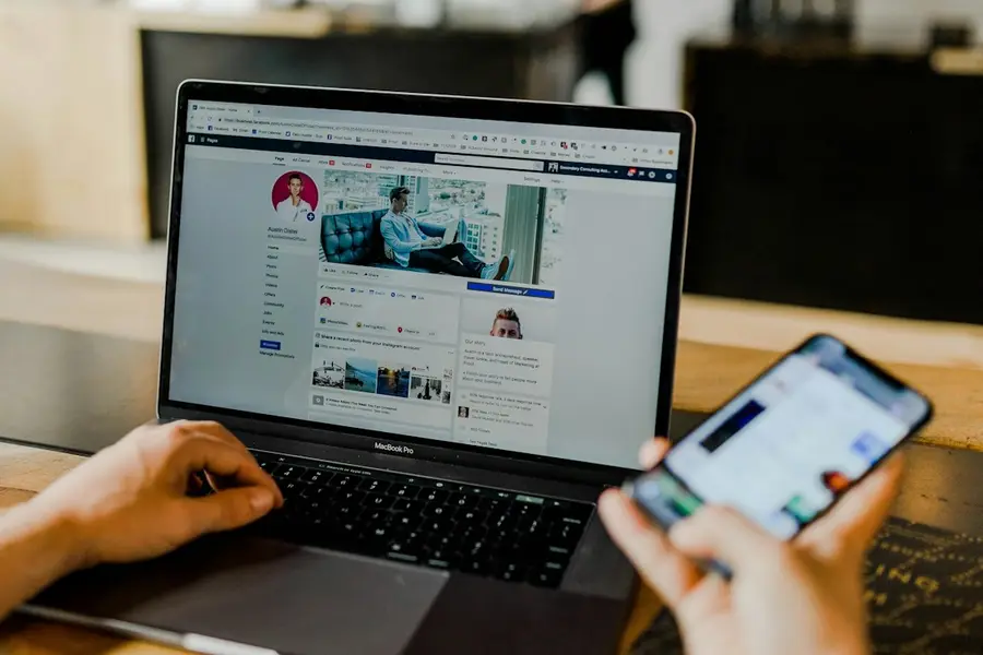 Persona revisando métricas de redes sociales en su laptop y celular
