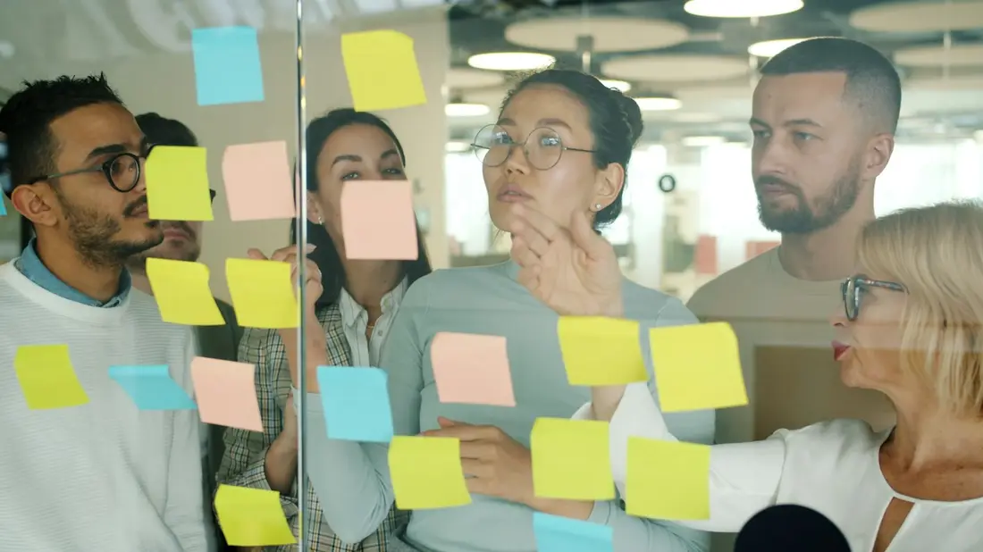 Equipo de trabajo organizando ideas con notas adhesivas